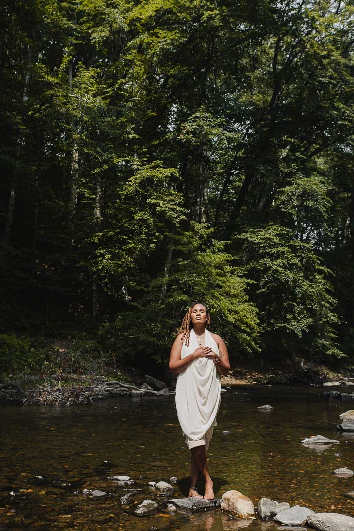 Charika White standing in a Maryland creek with her hand on her chest, culturally attuned ADHD evaluation for adults