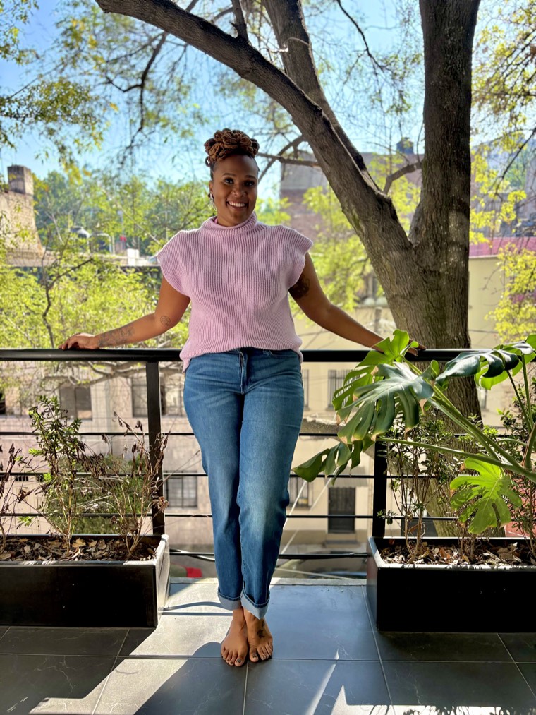 Charika White standing at a balcony railing, licensed Black female therapist for Baltimore adults