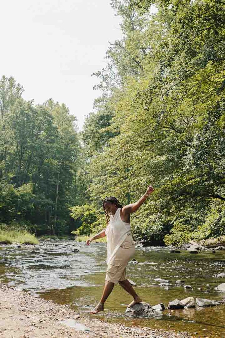 Charika White stepping across stones in a creek, the step-by-step structure of CBT in Washington DC