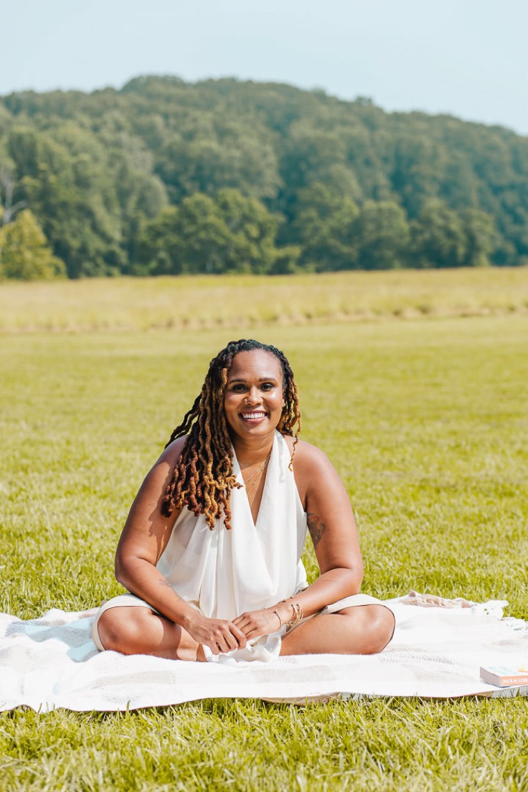 Charika White seated and turned toward the camera in warm light, the community care behind therapy for Black adults across Maryland