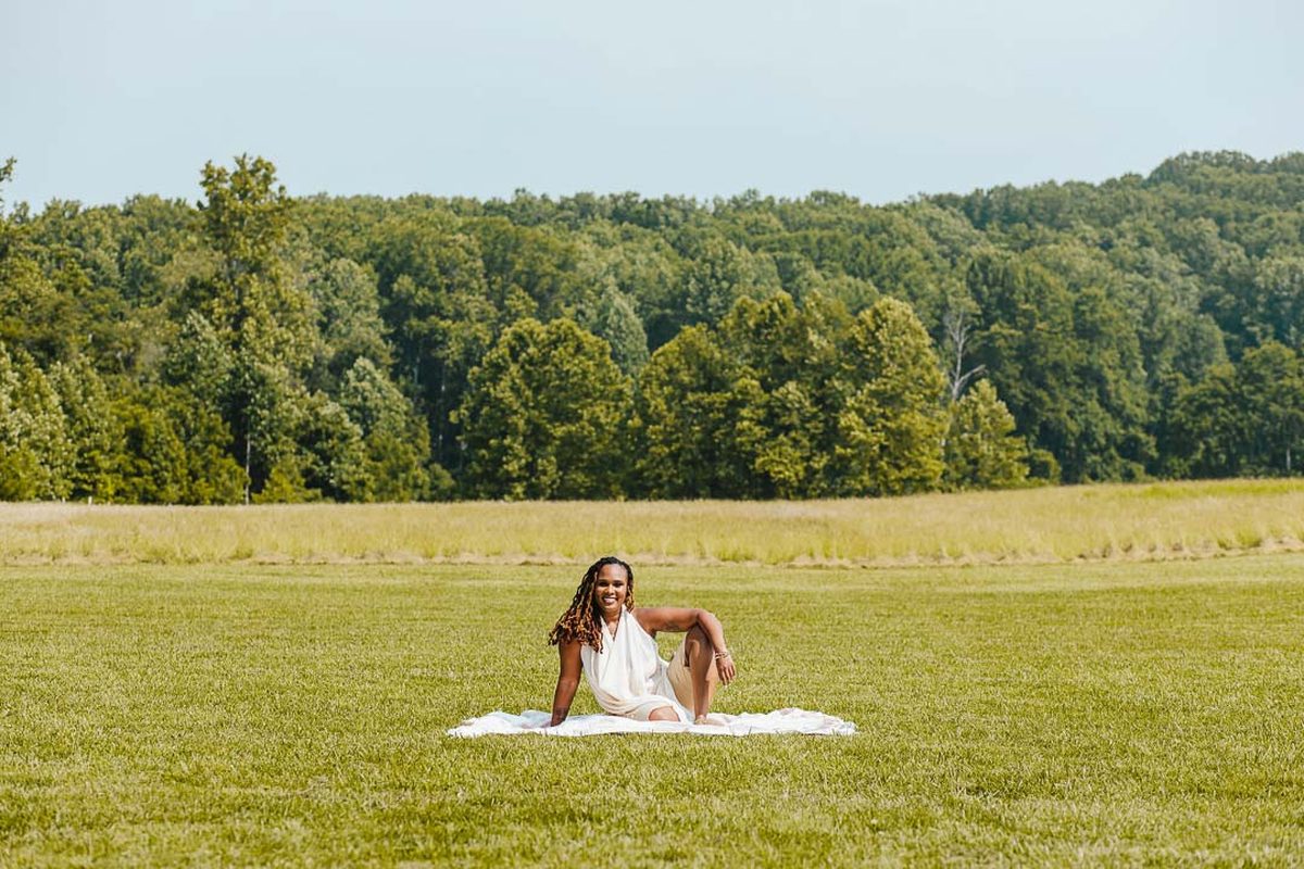 Charika White sitting in an open field, culture change consulting for Washington DC and Maryland teams
