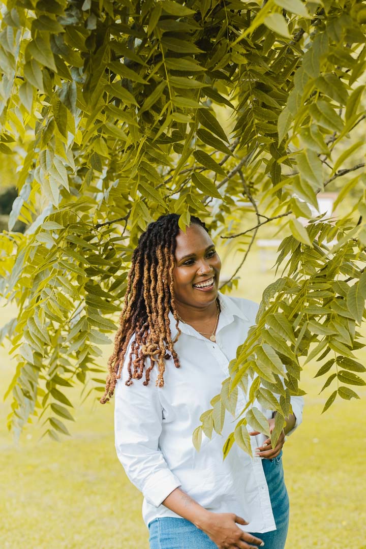 Charika White laughing beneath walnut leaves, culturally attuned Black therapist serving Maryland adults