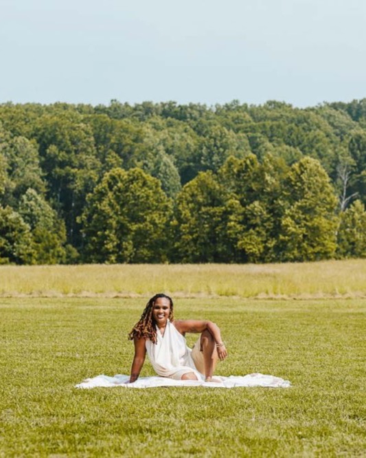 Charika White, licensed psychotherapist in Maryland, at ease in an open field, the unhurried care behind her virtual therapy sessions