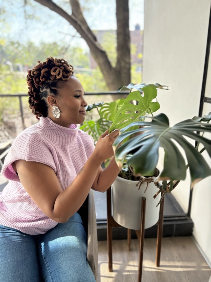 Charika White of Life Migration Therapy tending plants in natural light, the calm grounded feel her Maryland and DC clients experience