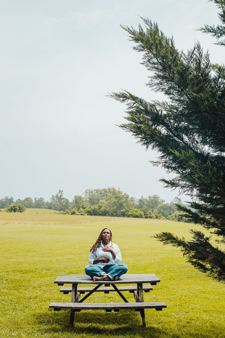 Charika White seated cross-legged with a hand on her heart, the grounded pace of private pay counseling in Maryland and Washington DC