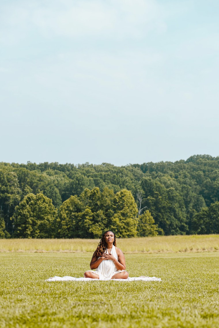Charika White meditating in an open Maryland field, the calm behind sliding scale therapy for Washington DC and Maryland adults