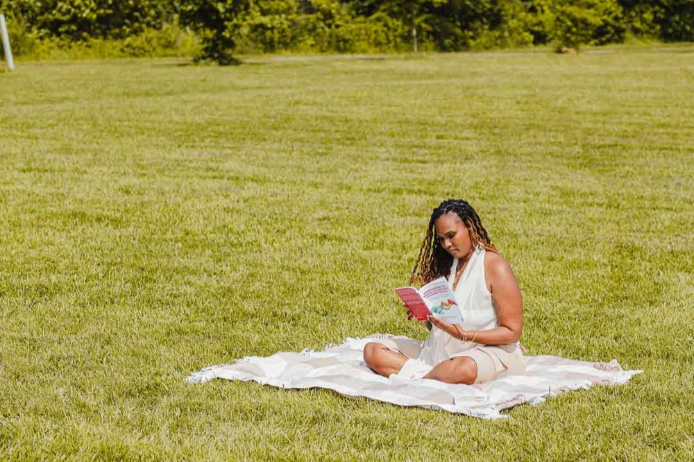 Charika White reading in a Maryland field, the careful review behind each VAWA psychological evaluation report for DC self-petitions