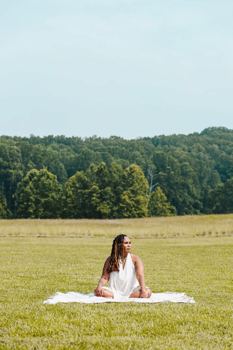 Charika White seated quietly in an open field, the unhurried space survivors find in a VAWA evaluation at Life Migration Therapy DC