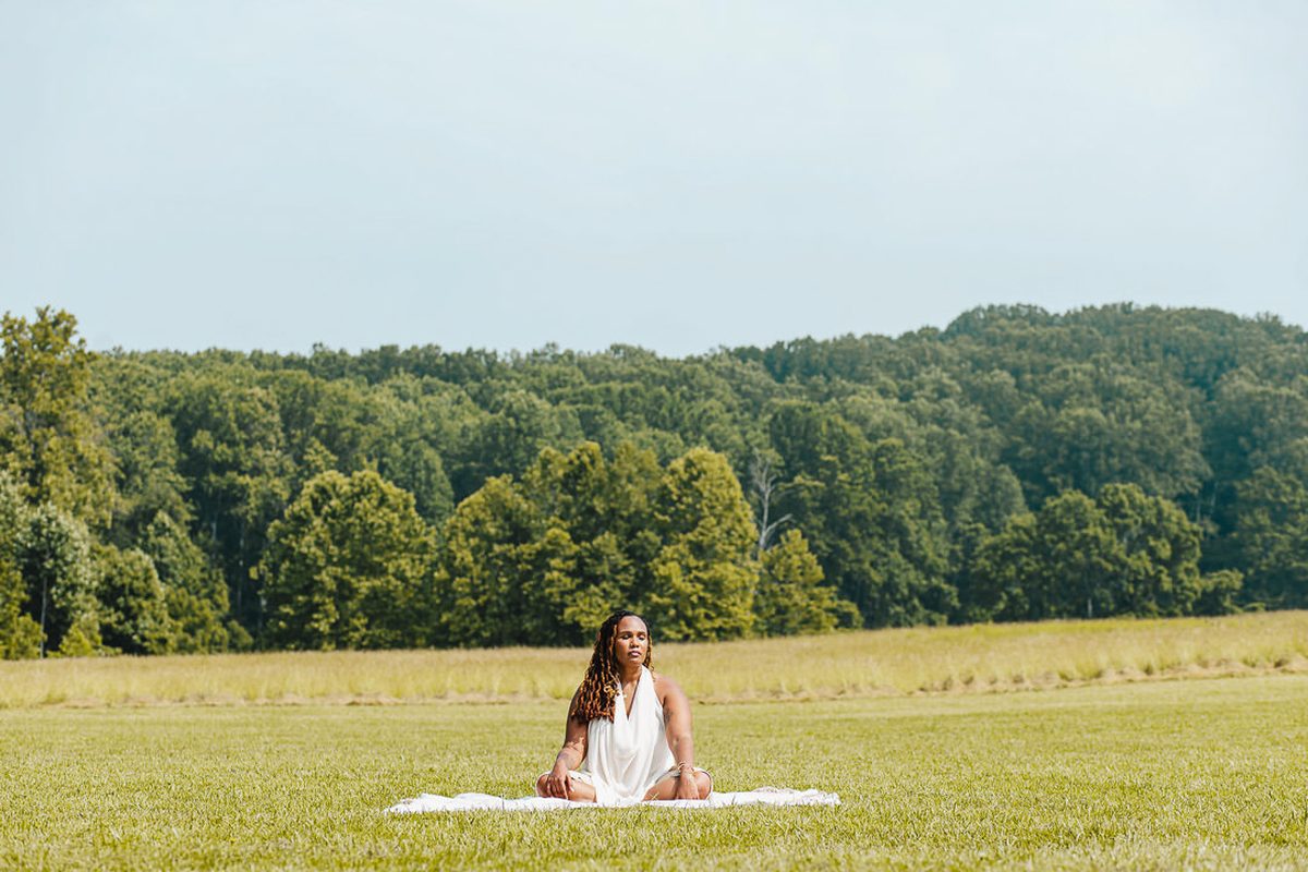 Charika White sitting in an open field, virtual cognitive behavioral therapy reaching Washington DC clients