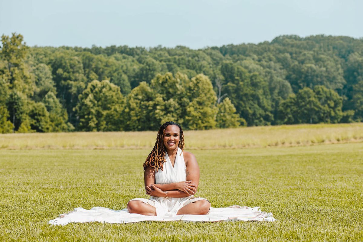 Charika White sitting in an open field, the room to breathe that Washington DC and Maryland organizations lose to chronic burnout
